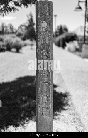 A greyscale vertical image of an old rusty sign that says 'Bus Stop' Stock Photo