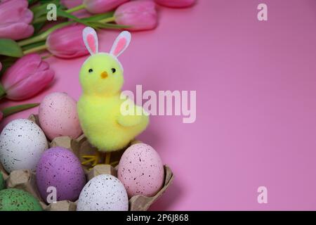 little yellow Easter chicken background with tulips and colourful eggs  Stock Photo