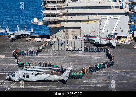 230307-N-TC847-1405 ADRIATIC SEA (March 7, 2023) Sailors from the state of Texas assigned to the Nimitz-class aircraft carrier USS George H.W. Bush (CVN 77) pose for a photo in the shape of their home state on the flight deck, March 7, 2023. The George H.W. Bush Carrier Strike Group is on a scheduled deployment in the U.S. Naval Forces Europe area of operations, employed by U.S. Sixth Fleet to defend U.S., allied, and partner interests. (U.S. Navy photo by Mass Communication Specialist 2nd Class Christine Montgomery) Stock Photo