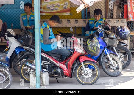 SAMUT PRAKAN, THAILAND, FEB 13 2023, Taxi drivers on motorbikes are waiting for passengers Stock Photo