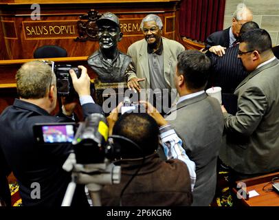 Jesse Rogers, a former Negro League player and barnstormer for the Kansas City Monarchs and a current ambassador for the Negro Leagues Baseball Museum in Kansas City poses beside a bust of his Monarchs manager John 'Buck' O'Neil inside the Missouri House of Representatives following a ceremony inducting O'Neil into the Hall of Famous Missourians at the state Capitol in Jefferson City on Monday, Feb. 27, 2012. (AP Photo/Jefferson City News Tribune, Kris Wilson)