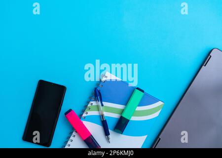 Several highlighter with a notebook next to a laptop and phone. Concept of old and new technologies Stock Photo