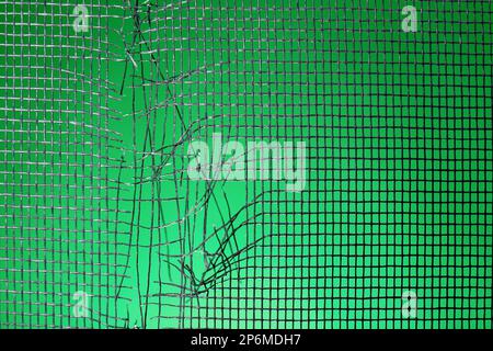 Torn window screen against green background, closeup Stock Photo