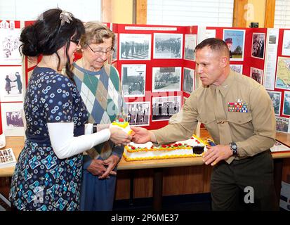 Mindy Decker, left, youngest in attendance, and Gene Blick, oldest in attendance, receives first slice of cake cut by the commander of Camp Lejeune, Col. Daniel J. Lecce, right, during the Women Marines Association 69th Anniversary of the Marine Corps Women's Reserve at Golden Corral in Jacksonville, N.C. Saturday, February 11, 2012. Blick served from 1951-1952 reaching Marine Sergeant, and Decker served from 2002-2011 reaching Marine Sergeant. (AP Photo/The Daily News, Don Bryan)