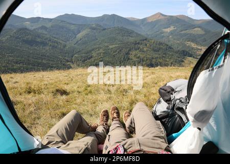 Couple resting inside of camping tent in mountains, closeup Stock Photo