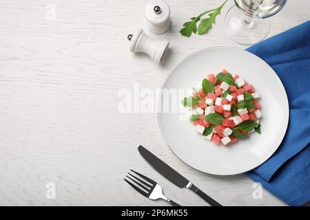 Delicious salad with watermelon, arugula and feta cheese served on white wooden table, flat lay. Space for text Stock Photo