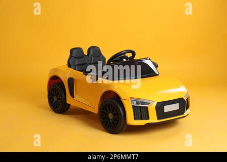 New bright toy car on yellow background Stock Photo