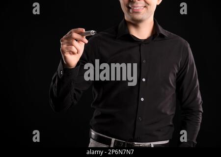 Business consultant with marker using virtual screen on dark background, closeup Stock Photo