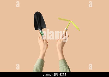 Female gardener with tools on beige background Stock Photo