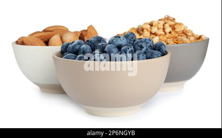 Ceramic bowls with almonds, blueberries and granola on white background. Cooking utensil Stock Photo