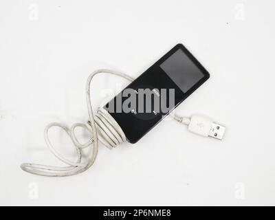 Closeup of a black vintage mp3 music player known as apple ipod nano with charging cable isolated in a white background Stock Photo