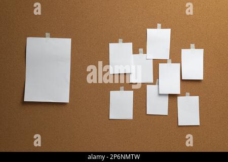 Blank white paper sheets on cork board Stock Photo