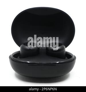black wireless noise cancelling earbuds head set with a charging power bank case isolated in a white background Stock Photo