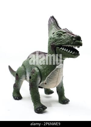 a green scary dinosaur mechanical toy with sharp teeth in its mouth isolated in a white background Stock Photo