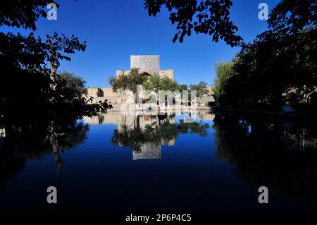 The Nodir Devonbegi Madrasah and the Divan-Beghi pond in the heart of the old city of Bukhara, Uzbekistan. Stock Photo