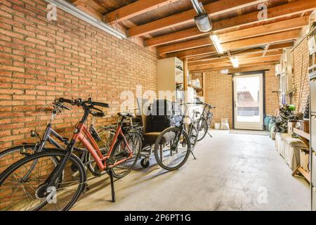 a room with bikes parked in front of the door and on the wall behind it is a brick wall that has been painted red Stock Photo