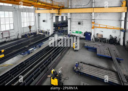 Long steel constructions assembling with welding in workshop Stock Photo