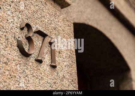 an old building with the letter n on it's side, and a red door in the back ground Stock Photo