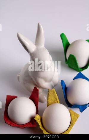 photo rabbit and multicolored egg carton with eggs on white background Stock Photo