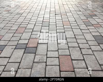 Sidewalk tiles. Closeup of paving slabs background. Street paving slabs. Cement block of the road. Cement brick squared stone floor background. Stock Photo