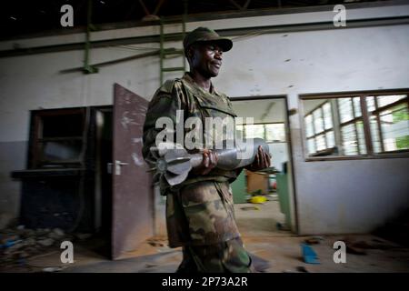 In a handout photograph released by the African Union-United Nations Information Support Team Monday, Aug.15, 2011, A Ugandan soldier serving with the African Union Mission in Somalia (AMISOM) carry shell that were used by the extremist group Al Shabaab to make improvised explosive devices. AMISOM troops and Transitonal Federal Government (TFG) forces dislodged remnants of Al Shabaab from the site following the withdrawal of most of the extremist group's forces from the city ten days ago, discovering the bomb making facility at the former steel factory in northern Mogadishu which contained evi