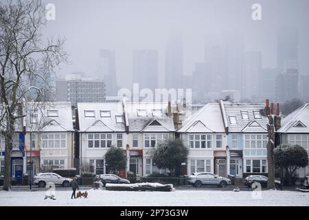 As March snow falls on south London, period homes are seen with white rooftops on a street bordering Ruskin Park, a public green space in Lambeth, on 8th March 2023, in London, England. Stock Photo