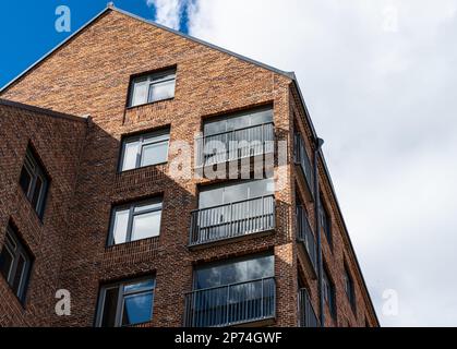 Looking up a tall newly constructed brick apartment building Stock Photo