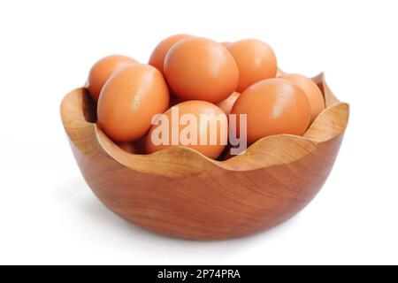 Fresh home grown eggs in wooden bowl isolated on white background Stock Photo