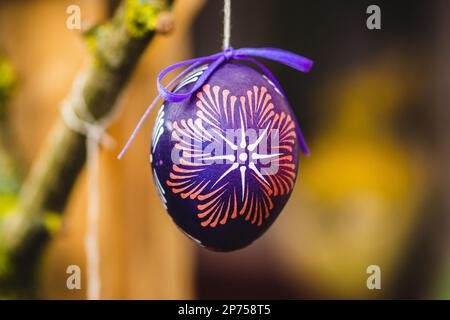 Traditional Lithuanian wooden colorful Easter egg, symbol of fertility and life painted with the symbols of nature, close up Stock Photo