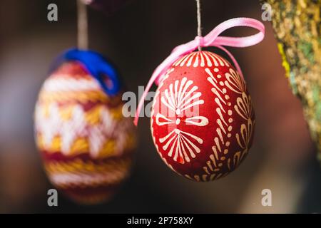 Traditional Lithuanian wooden colorful Easter egg, symbol of fertility and life painted with the symbols of nature, close up Stock Photo