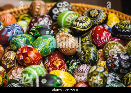 Traditional Lithuanian wooden colorful Easter eggs in a wicker basket, symbol of fertility and life painted with the symbols of nature Stock Photo