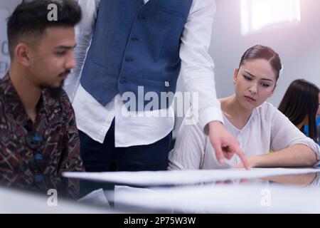 Teacher Giving Lesson to Diverse Multiethnic Group of Female and Male Students in College Room, Stock Photo