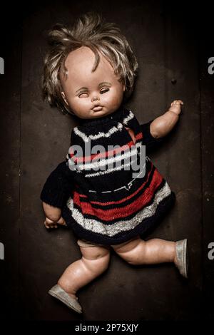 old broken doll on dark background Stock Photo