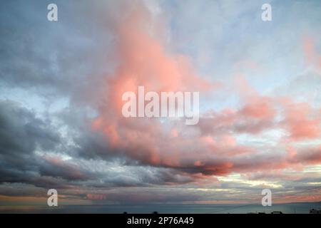 cloudy sky glowing pink and red due to setting sun over the sea Lanzarote, Canary Islands, Spain Stock Photo