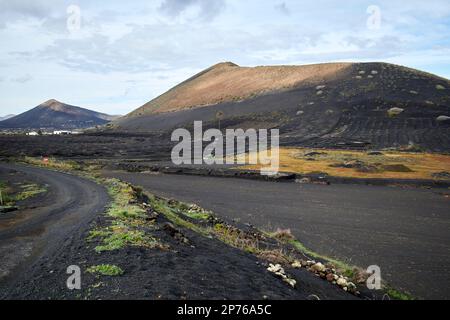 local dirt track unpaved road in the la geria wine making area of Lanzarote, Canary Islands, Spain Stock Photo
