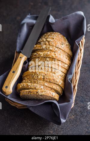 Sliced whole grain bread. Tasty wholegrain pastry with seeds in the baket. Stock Photo