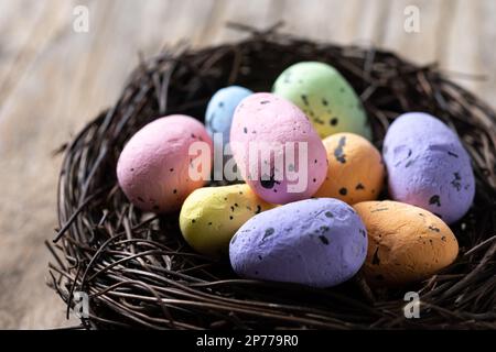Colorful Easter eggs inside a nest on wooden table Stock Photo