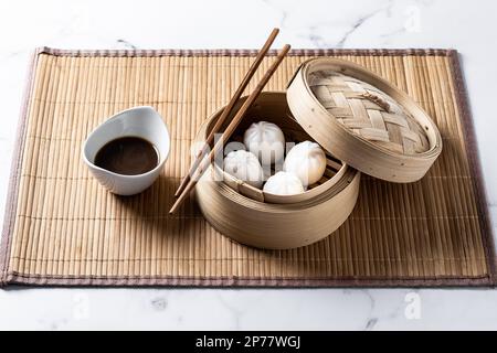 Dumplings in bamboo steamer on marble background Stock Photo