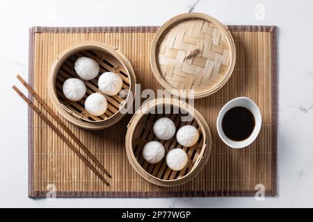 Dumplings in bamboo steamer on marble background Stock Photo