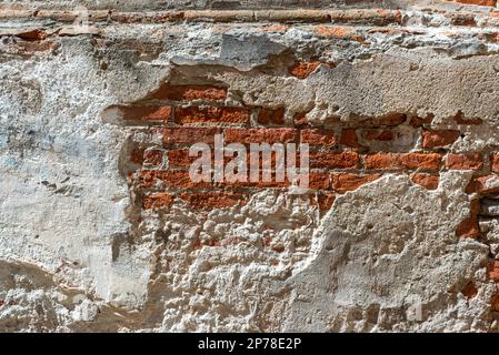 Wall texture with ancient plaster and peeling background with exposed red brick. Ideal for background with copy space Stock Photo