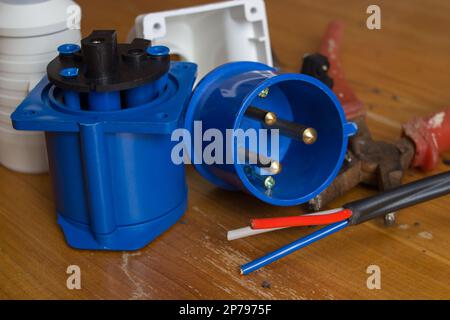 Worker man electrician is repairing damaged sockets in the apartment, installation of new closeup Stock Photo