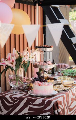 Candy bar with various sweets, pink cake and pastries on the table. Stock Photo