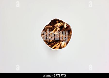 Single unlit cigarette stick macro detail shot of ground tobacco leafs front view isolated on white. Stock Photo