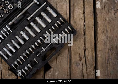 Close up of a opened tool box. Wooden background. Wrenches and bits. Stock Photo