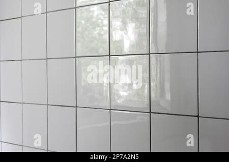 White faience tiles wall in an apartment bathroom side view close up shot. Stock Photo