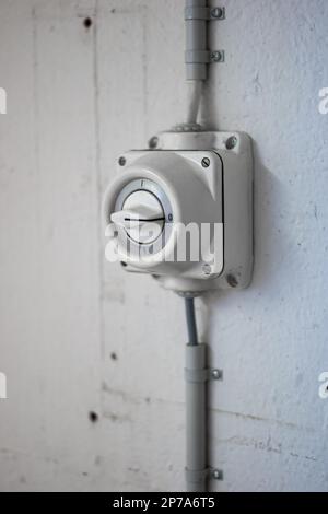 Wall mounted old fashion industrial grade power switch close up shot no people. Stock Photo