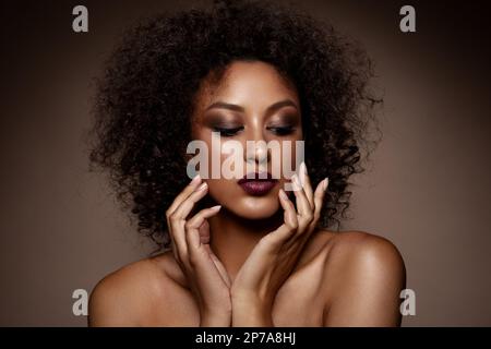 Portrait closeup Beauty fantasy african woman face. Golden shiny skin. Fashion model girl goddess hand fingers posing. Professional metallic makeup High quality photo Stock Photo
