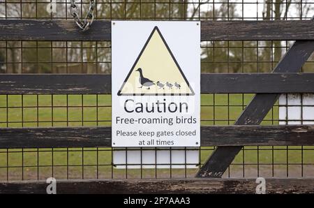 Sign on a gate: Caution, free-roaming birds, please keep gates closed at all times Stock Photo