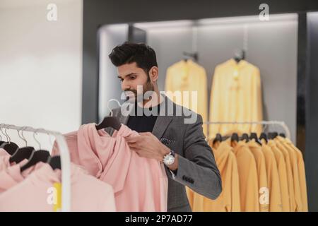 Young man working in clothing store Stock Photo