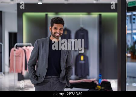 Young man working in clothing store Stock Photo